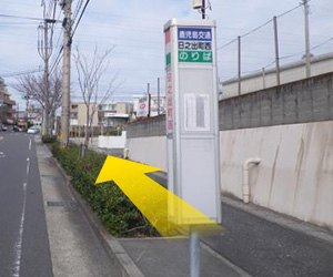 日之出町西バス停で下車し、バス通り沿いに上ると右手に空き地 がある日之出町交差点が見えてきます。